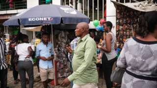 A man listen the news on his phone in downtown Bujumbura