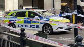 Image of a police car surrounded by multiple cordons by H&M at Oxford Circus