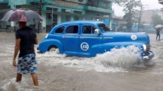 A vintage car in Havana's flooded streets