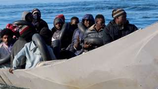 Migrants are pictured on a metal boat as Tunisian coastguards try to stop them at sea during their attempt to cross to Italy, off Sfax, Tunisia April 27, 2023
