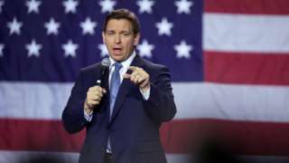 Ron DeSantis at a rally in front of a US flag