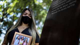 Thamires da Silva Netto, 29, who lost five relatives to the coronavirus disease (COVID-19), participates in a ceremony at the "Infinity Memorial" for the victims of the covid-19, where the name of her mother and sister were written, at the Penance Cemetery in Rio de Janeiro, Brazil, 08 January 2021