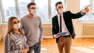 Stock image of an estate agent showing a couple a property