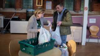 A man receives a bag from a food bank in Coventry