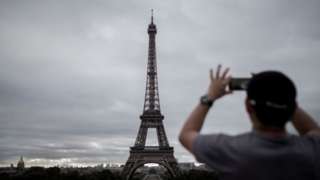 Homem fotografando a Torre Eiffel