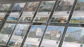 Properties for sale in an estate agent's window