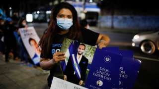 A supporter of the Nuevas Ideas political party holds calendars with the picture of El Salvador"s President Nayib Bukele as she takes part in a rally during the last day of election campaign in San Salvador, El Salvador, February 24, 2021