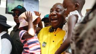 African National Congress (ANC) president and South African President Cyril Ramaphosa (C) holds children during a walkabout and a meet and greet at the Chris Hani mall in Ekurhuleni on March 10, 2024