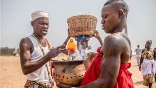 A Voodoo follower holds a fetish during the Voodoo Festival in Ouidah, Benin, on January 10, 2022