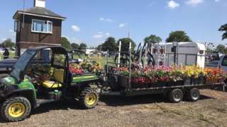 A tractor attached to a cart of flowers