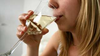 Woman takes a drink of wine from a glass