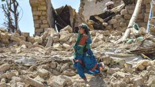 A child walks amidst the rubble of damaged houses following an earthquake in Bermal district, Paktika province, on June 23, 2022.