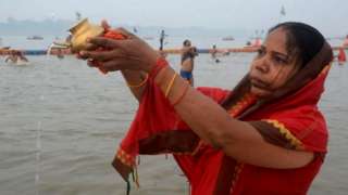 Woman offers prayers during Magh Mela in Prayagraj