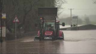 A tractor drives through flood water in Ribchester