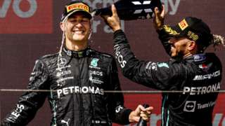 Lewis Hamilton pours champagne over team-mate George Russell on the podium