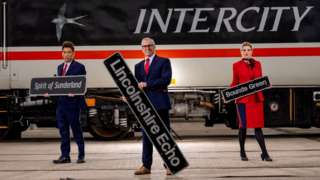 Three LNER workers hold the name plates in front of the InterCity