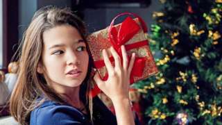Girls shakes a present to figure out what's inside