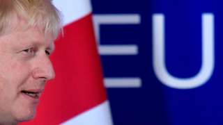 Boris Johnson next to British flag and EU sign