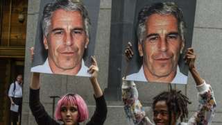 Protesters in New York hold up placards bearing the face of Jeffrey Epstein