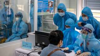 Các nhân viên y tế Việt Nam thu thập thông tin từ một người được tiêm vaccine AstraZeneca COVID-19 hôm 8/3/2021