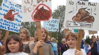 Children with placards at a Procession Against Poo, in Bungay, Suffolk