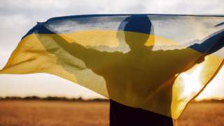 Person in silhouette with Ukrainian flag