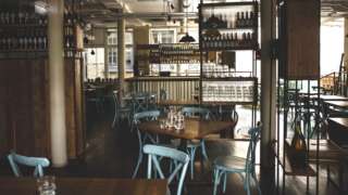 Image showing empty chairs and tables in a restaurant in London.