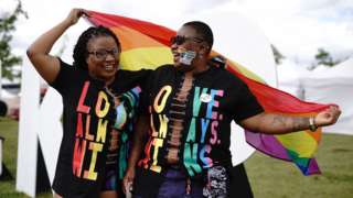 People hold a rainbow flag at UK Black Pride
