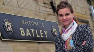 Jo Cox standing next to Batley sign