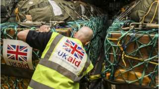 File pic of a UK aid worker loading an RAF plane with supplies