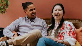 A man and woman laughing together.