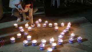 People light candles at Tel Aviv museum