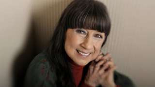 Judith Durham, wearing a green cardigan and red top, poses for portraits at the Hilton on the Park in November 2011