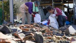 Residents collect belongings after an earthquake in Japan