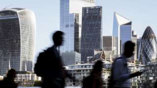 Business people walking to work with view of the financial district behind in London, England
