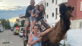 Emma Baxter and Daniel Metcalf with their daughters Milly and Lilly with a camel on holiday in Turkey