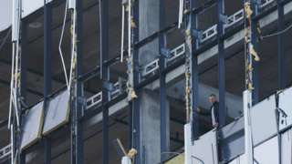 A member of the security services investigates the damaged building following a reported drone attack in Moscow, Russia, on 24 July 2023
