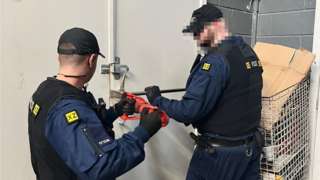 Police forcing door open at warehouse