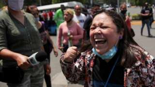 A resident reacts as she arrives at the site where an overpass for a metro partially collapsed with train cars on it at Olivos station in Mexico City