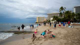 Visitors play on Waikiki Beach in Honolulu, Hawaii on December 7, 2021