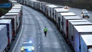 Police patrol along the M20 in Kent where freight traffic is parked up near to Folkestone services whilst the Port of Dover remains closed.