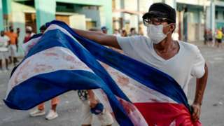 A man waves a Cuban flag during a demonstration against the government of Cuban President Miguel Diaz-Canel in Havana