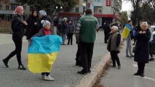 Girl in Kherson holds Ukrainian flag