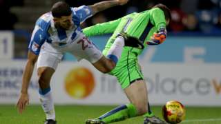 Bristol City goalkeeper Frank Fielding handles the ball outside the area as Huddersfield Town's Nahki Wells challenges