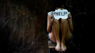 Woman holding help sign