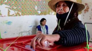 A Tunisian woman votes during a referendum on a draft constitution put forward by the country's President, at a polling station in Kasserine, on July 25, 2022