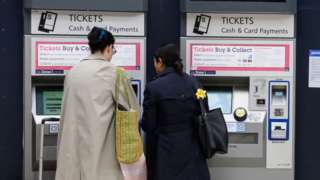 People using a ticket machine
