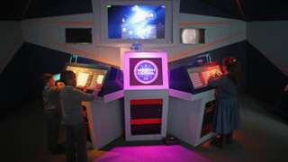 Children play on Mission Control in the National Videogame Arcade