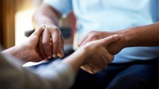 Woman holding man's hands