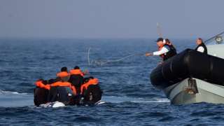 Border Force officers assist 20 Syrian migrants aboard HMC Hunter after they were stopped as they crossed The Channel in an inflatable dinghy